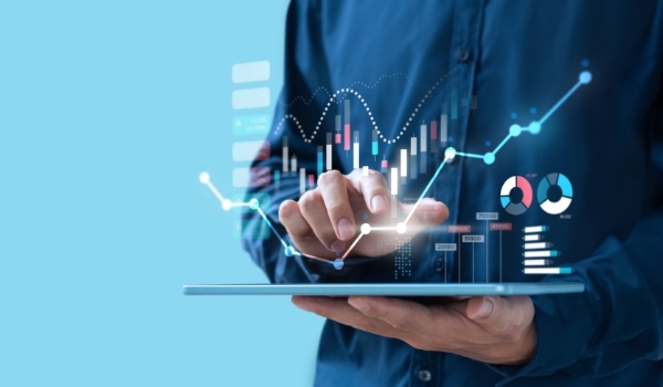 hand holding tablet with virtual charts and graphs